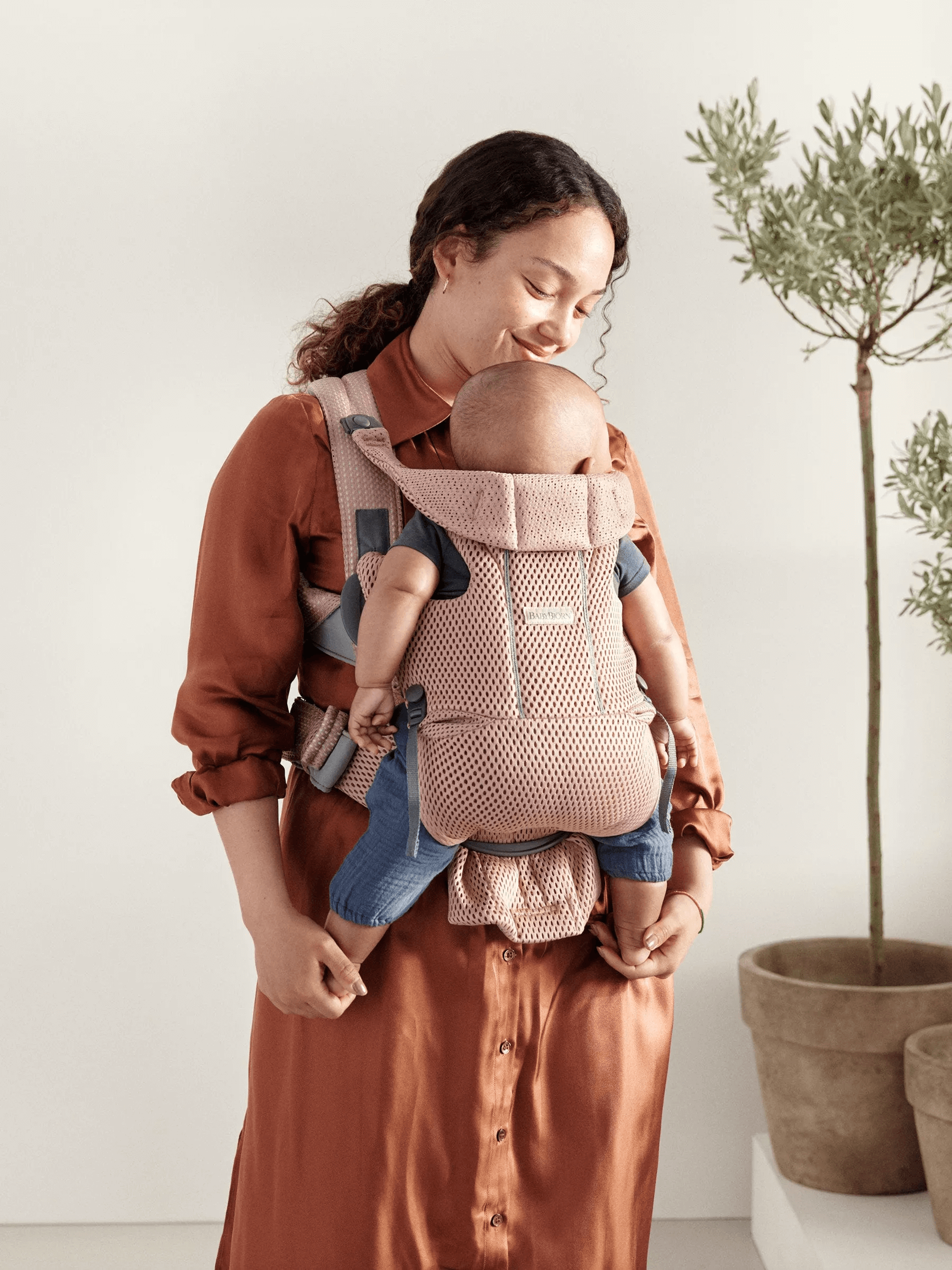 Mom holding baby in  BabyBjorn Baby Carrier Free in Dusty Pink 3DMesh